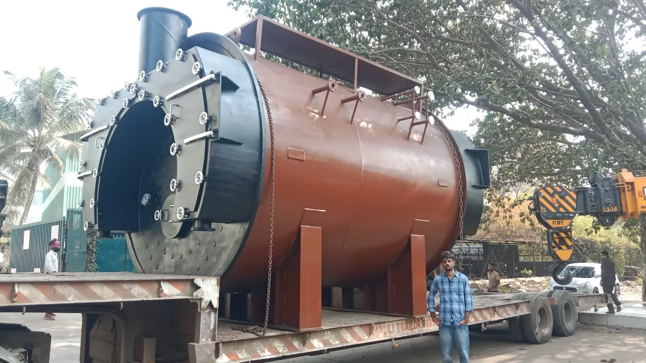 Huge rust-red industrial boiler on a low-bed trailer, with a man standing alongside for scale